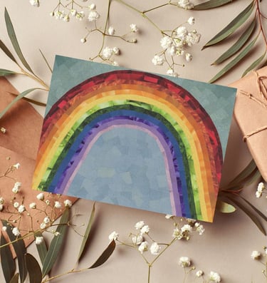 Handmade rainbow greeting card surrounded by baby's breath flowers and kraft paper gifts.