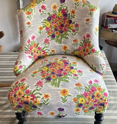 Chauffeuse Napoléon III recouverte d'un tissu à motif floral sur fond gris