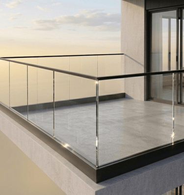 Modern high-rise apartment balcony featuring glass railings and a stunning sunset view.