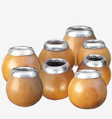 A collection of traditional wooden yerba mate gourds with polished silver rims.