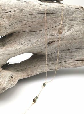 Sautoir de style chapelet, posé sur un tron de bois flotté