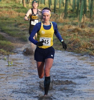 a woman running in a muddy road