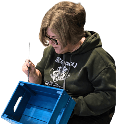 A lady painting a crate- beginner level of furniture painting class with Absolutely Mintage