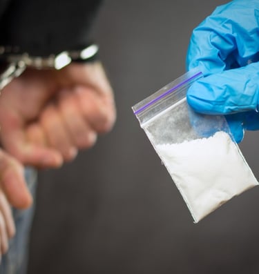 person in handcuffs and drugs in bag being confiscated
