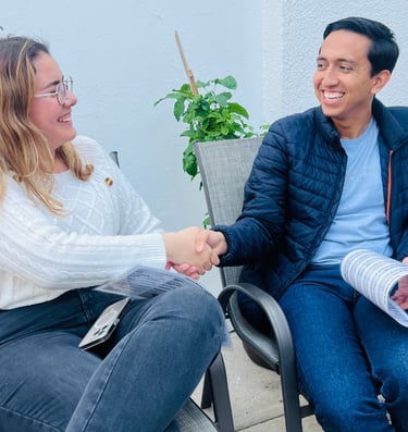 Dos profesionales tomando un curso de inglés coversacional al aire libre. 