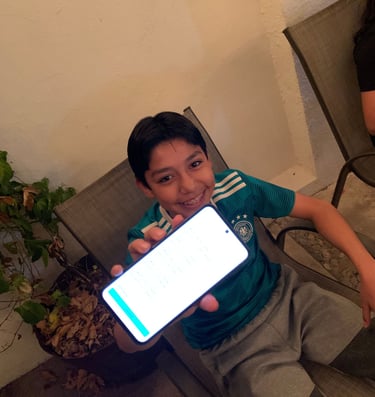 Un joven sosteniendo felizmente un celular mostrando su puntuación de inglés en una aplicación digital. 