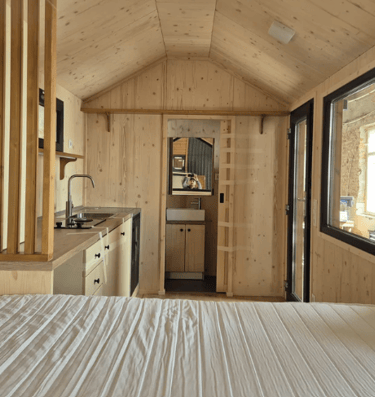 Tiny house kitchen surface on the left and on the front bathroom