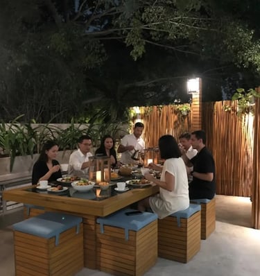 a group of people sitting at a table with food