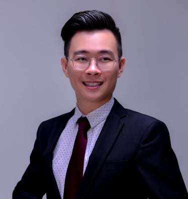 a man in a suit and tie standing in front of a white wall