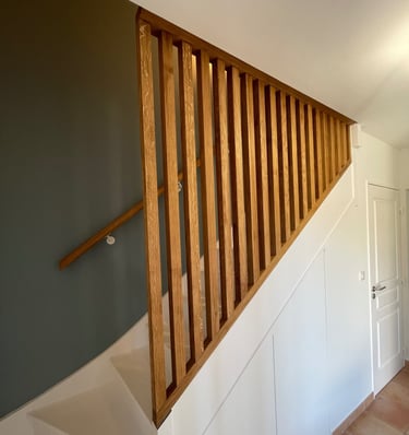 a staircase with a wooden handrail and a door