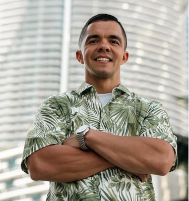 Cody Sechelski in a hawaiian shirt and wearing a watch posing with a smile