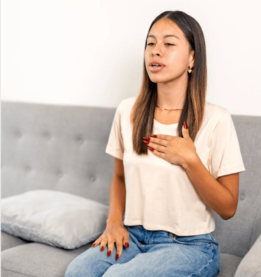 a woman sitting on a couch with a remote control