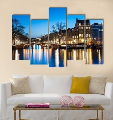 Five-panel canvas print of a lit bridge and buildings reflecting on a canal, mounted above a white c