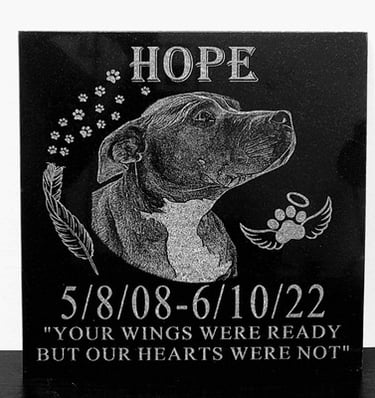 Laser-engraved granite plaque with a portrait of a dog named Hope and the text 'Your wings were read