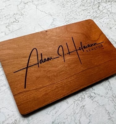 Wooden NFC digital business card with the name Adam J. Hofmann engraved.