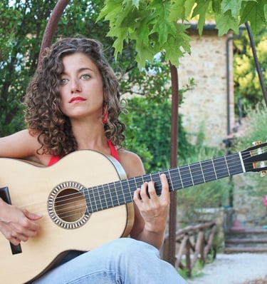 a woman with curly hair and a guitar