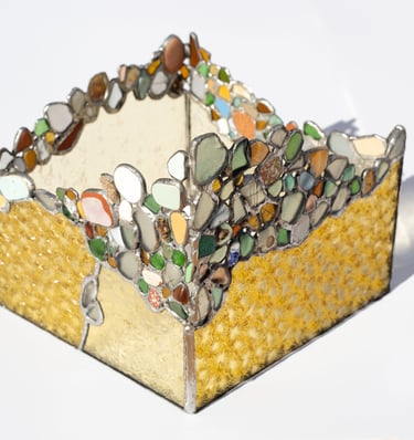 Portavelas artesanal de vitral con vidrio texturizado amarillo y un borde colorido de vidrio marino.