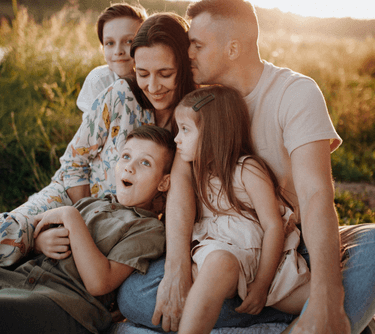 a family of four children sitting on a blanket