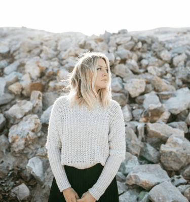 a woman in a white sweater and black skirt