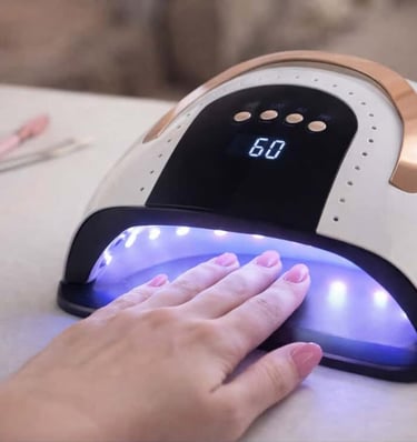 LED nail dryer curing gel polish on a hand during an at home manicure