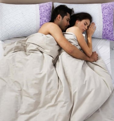 Couple sleeping closely together with supportive pillows for comfortable side sleeping