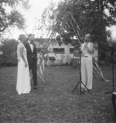 Traurednerin Silke steht bei einer freien Trauung im Freien und spricht vor den Gästen eine persönliche Zeremonierede.