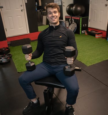 dustin king holding weights in his gym