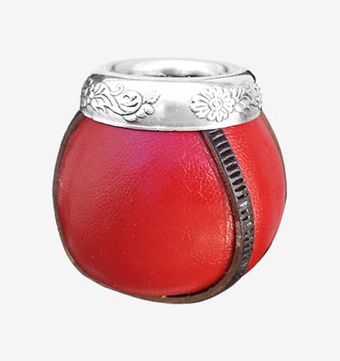 Red leather yerba mate gourd cup with ornate silver rim and floral carvings.