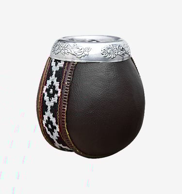 Traditional leather-wrapped yerba mate gourd with silver floral rim and woven geometric pattern.