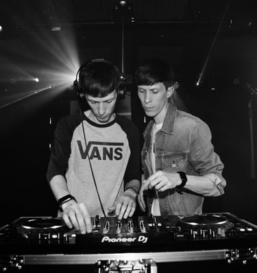 two men standing in front of a dj booth