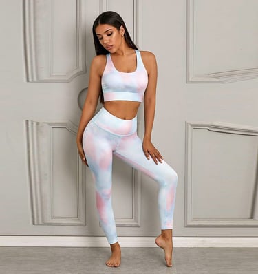 a woman in a pink and blue tie dye yoga outfit