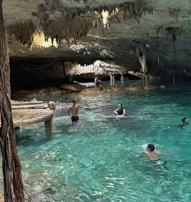 a group of people swimming in a cave