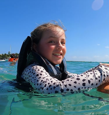 a girl in a polka dotty shirt is holding a dog