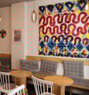 a restaurant with a large painting on the wall
