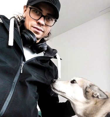 man with glasses and black baseball cap with gray dog