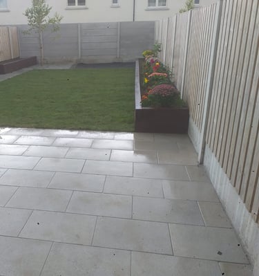 a backyard patio with a large lawn and a fenced in area