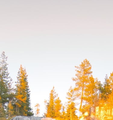 Paulina Falls waterfall flowing over rocky cliffs in Central Oregon at sunset.