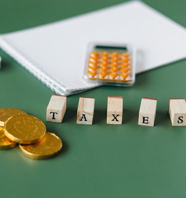 gold coins, calculator and word taxes show gold ira taxes and learning potential tax benefits