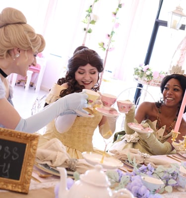 Tiana, Belle, and Cinderella cheers with tea cups