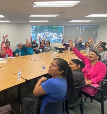 People around a table raising their hands