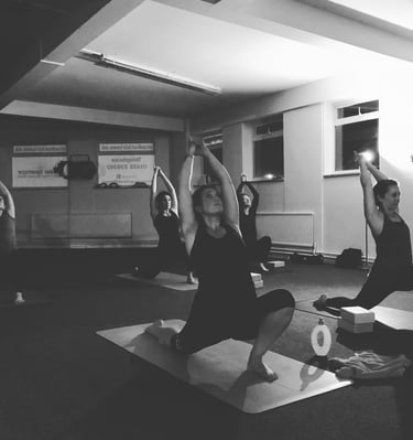 a group of people doing yoga poses in a gym