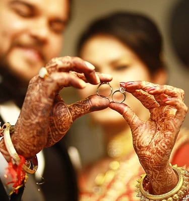 Bride and groom holding the wedding ring