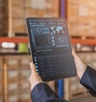 a man in a warehouse with a tablet computer and a tablet