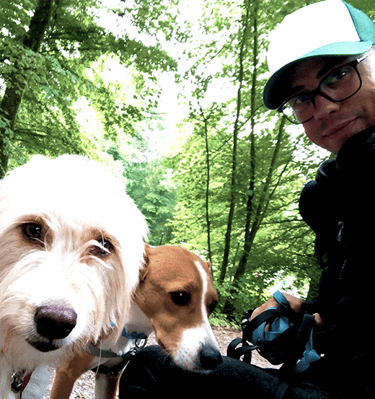 Foto von einem Mann mit zwei Hunden im Wald