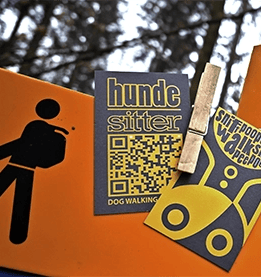 www.hunde-sitter.pro visit cards attached to the sign in the forest