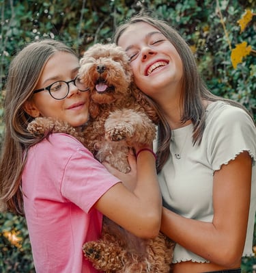 ritratto di bambine sorridenti col proprio cane in natura