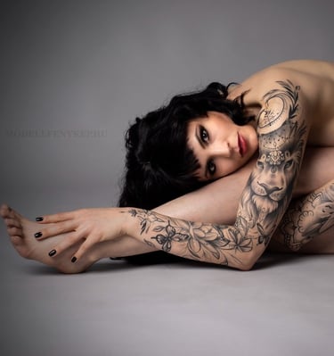 a beautiful woman with tattoos on her arm and arms implied nude glamour