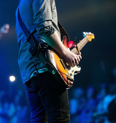 person playing electric guitar in front of audience