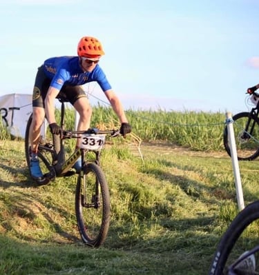 a man riding a bike on a grassy hill