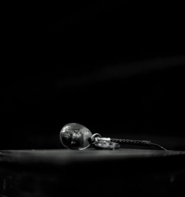 a black and white photo of a silver earring